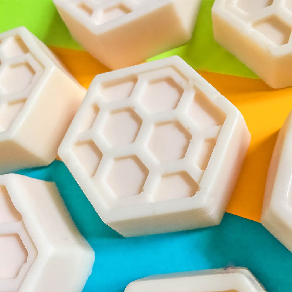 Our homemade honey goats milk soap bars sitting on a colorful  background