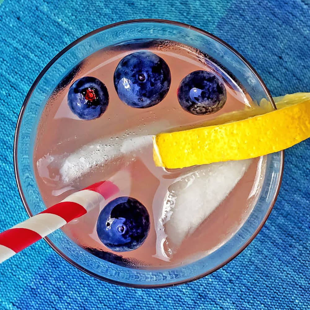 A glass of our lavender lemonade garnished with blueberries