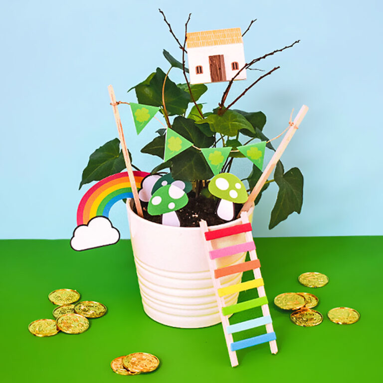 Our DIY leprechaun garden kids craft sitting in front of a green and blue background surround by play golden coins.
