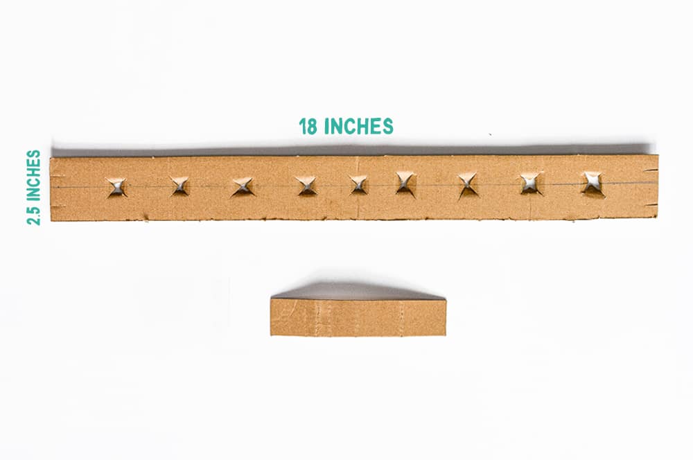 Cut cardboard strip for base and holes for twig candles | Instructions for a DIY Twig Menorah