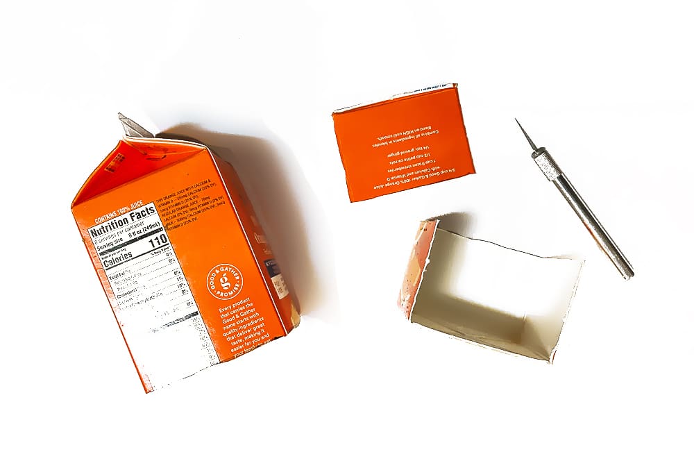 Cut apart your juice carton with a utility knife or scissors