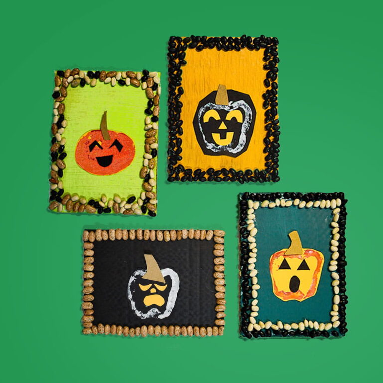 Four of our potato stamp pumpkin art pieces hanging on a green background.