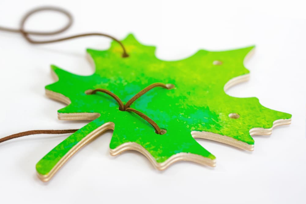 Our leaf threading fall fine motor skill activity siting on a white background