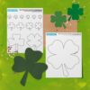 Printed pages of our shamrock and four-leaf clover template set sitting on a green background with green cutout shamrocks clovers and other decorative elements