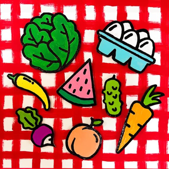 Pieces of our diy cardboard farm market food play set printable bundle sitting on a red checked tablecloth