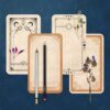 Four of our DIY tarot cards sitting on a dark blue painted background with dried foliage and pencils