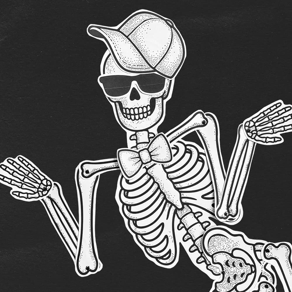 A life-sized paper skeleton decorated with paper accessories sitting on a black background