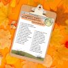 free-printable-halloween-nature-scavenger-hunt-list One of our free printable Halloween nature scavenger hunt pages in a clipboard sitting on an orange background surrounded by colorful fall leaves